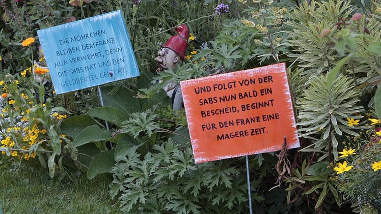 In einem Ebermannstadter Vorgarten wird die Straßenausbau-Beitragssatzung durch Schilder kommentiert. Foto: Josef Hofbauer