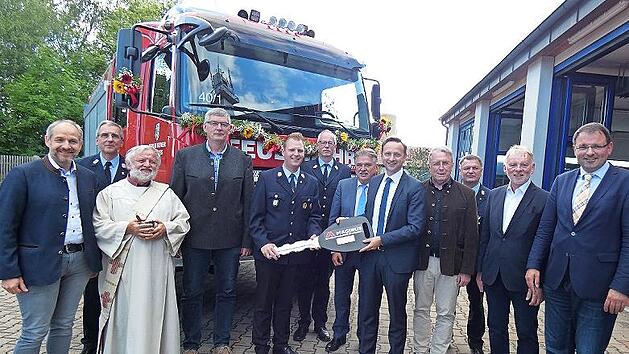 Die Feuerwehrler aus Mainleus freuen sich bei der offiziellen Schl&uuml;ssel&uuml;bergabe durch B&uuml;rgermeister Robert Bosch an Kommandant Christoph Zimmermann &uuml;ber das neue Fahrzeug.