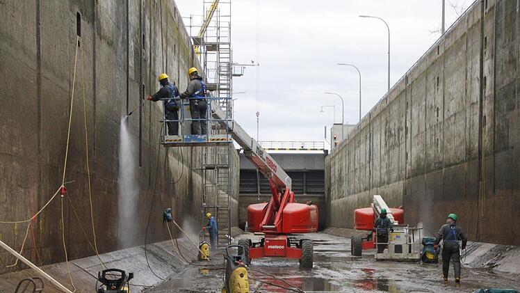 Es wuselt auf der Großbaustelle: Arbeiter reinigen die Betonwände der Schleusenkammer. Anschließend werden gefundene Risse dokumentiert, mit den Aufzeichnungen der letzten Trockenlegung vor sechs Jahren abgeglichen und bei Bedarf mit Kunstharz verpresst.  Foto: Andreas Schmitt