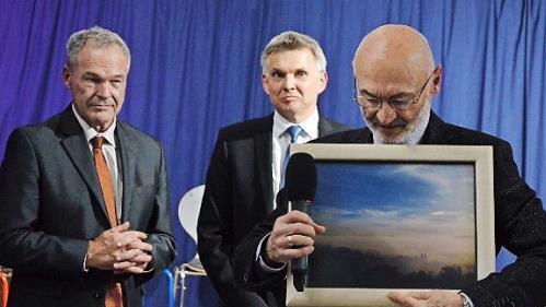 Reiner Sesselmann (rechts) zeigt ein Foto der Abgaswolke der Trabis im Stau vor der Gebrannten Brücke am 12. November '89. Dahinter Frank Rebhan und Heiko Voigt (rechts). Fotos: Rainer Lutz
