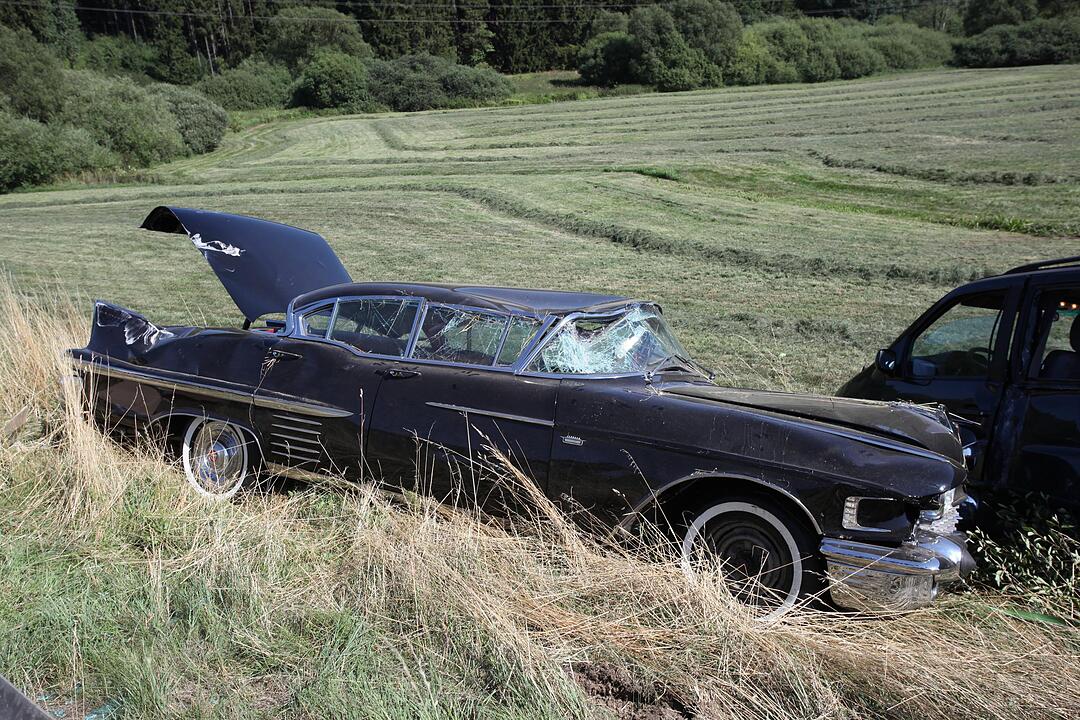Mit Cadillac beladener Auto-Anhaenger kommt von der Fahrbahn ab