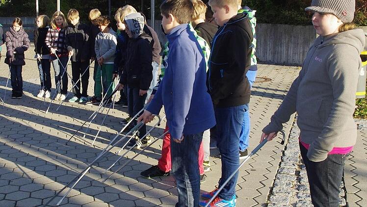 Die Schüler üben den Umgang mit dem Taststock. Mit im Bild ist Eva Telje (rechts). Foto: Heike Schülein