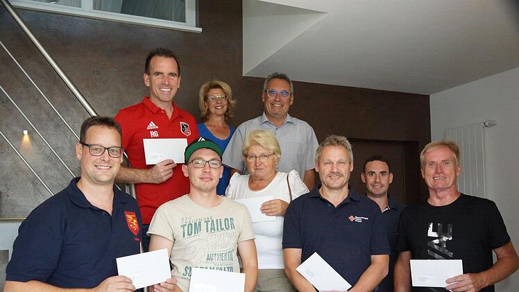 Spende: Tobias Pfülb (Fuschter Musikanten), Alexander Lebsak (Feuerwehr), Brigitte Burtchen (Obst- und Gartenbauverein), Stephan Kippes (Rotes Kreuz), Tobias Stöth, Rainer Lell (Faschingsclub) und hinten René Gerner (FC Fuchsstadt) sowie Birgit und Mathias Stöth. Foto: Guzy
