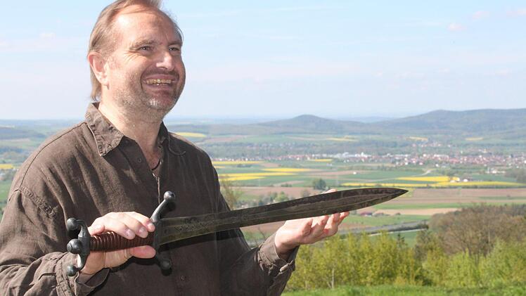 Kabarettist Helmut Vorndran hat sich auch zum Kenner historischer Zusammenhänge entwickelt. Das Schwert in Händen, sprach er u. a. von der Schmiedekunst der Kelten. Foto: Markus Häggberg
