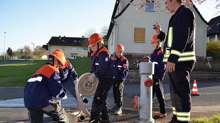 Info am Oberflurhydranten. Kommandant Thomas Geis erklärt, was Ramon (von links), Leon, Linus, Simon und Daniel beachten müssen. Foto: Kathrin Kupka-Hahn