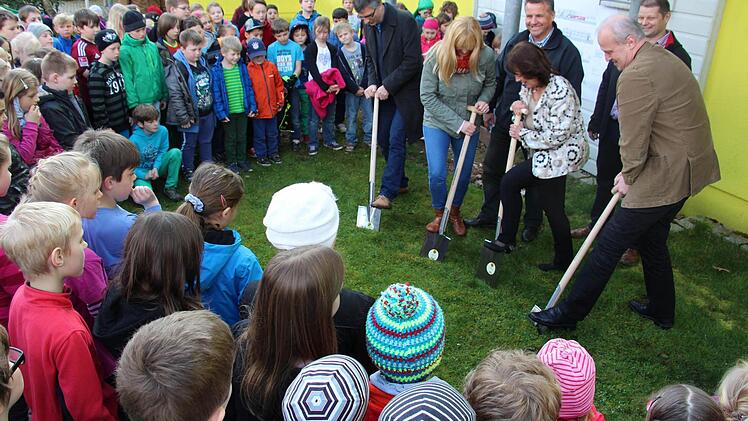 Die Kinder schauen beim Spatenstich an der Anton-Wölker-Schule zu. Ab Donnerstag wird dort Krippe, Kita und Kindergarten gebaut. Foto: Christian Bauriedel