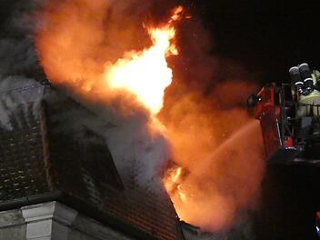 Die Flammen schlagen aus dem Dach, die Feuerwehr löscht über die Drehleiter, nachdem sie die Bewohner gerettet hat.