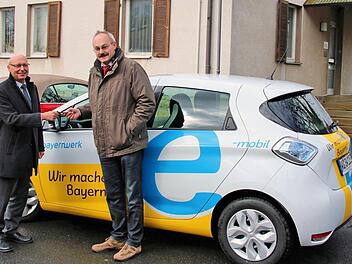 Bürgermeister Fridolin Zehner (rechts) und einige Rannunger Gemeinderäte sowie Bürger werden in den nächsten zwei Wochen das Elektroauto testen. Günter Jira, der stellvertretende Leiter der Abteilung Kommunen und Kooperationen des Bayernwerks in Unterfranken, übergab den Schlüssel.  Foto: Dieter Britz