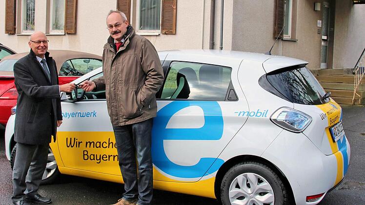 Bürgermeister Fridolin Zehner (rechts) und einige Rannunger Gemeinderäte sowie Bürger werden in den nächsten zwei Wochen das Elektroauto testen. Günter Jira, der stellvertretende Leiter der Abteilung Kommunen und Kooperationen des Bayernwerks in Unterfranken, übergab den Schlüssel.  Foto: Dieter Britz