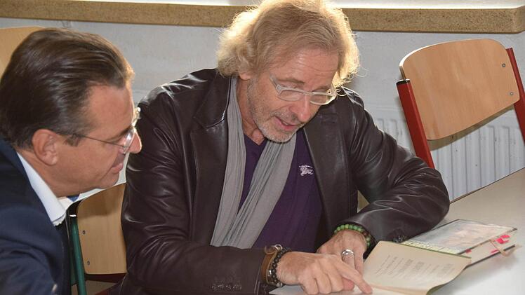 Gottschalk liest die Namen seiner Mitschüler in einem alten Jahresbericht. Foto: Ronald Rinklef