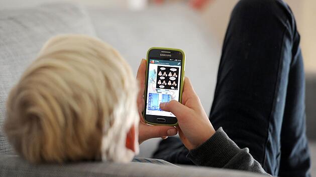 Ein Jugendlicher liest auf Whatsapp Nachrichten.  Foto: Tobias Hase /dpa