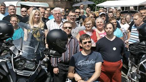 Elke Bohn (Mitte, rotes Shirt) mit einigen der Motorradfahrer und Mitarbeitern der Mainfr&auml;nkischen Werkst&auml;tten.