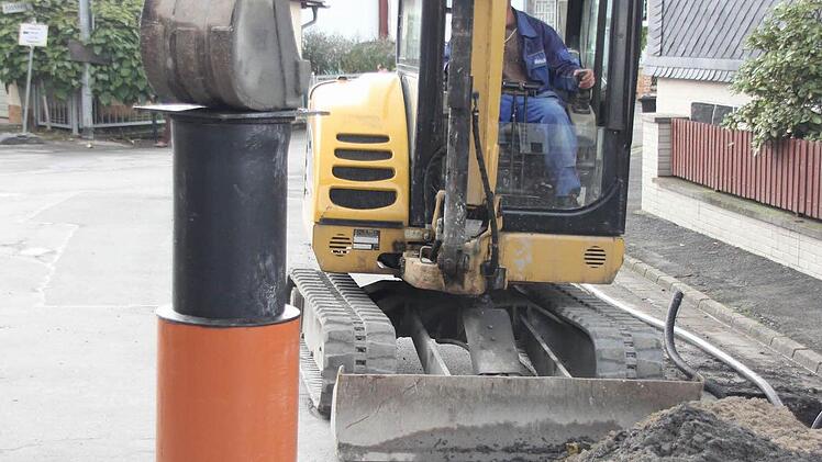 Ein Bagger drückt den Kanaleinlass in das Rohr...  Foto: Friedwald Schedel