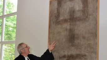 Pfarrer Joachim Pennig vor einem der ausgestellten Bilder. Foto: Björn Hein