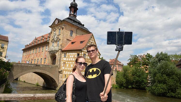 Und das Alte Rathaus darf mit aufs Bild. So wie Lisa und Robin kann man den Selfiestick einsetzen. Aber er taugt, wenn's sein muss, auch als ...