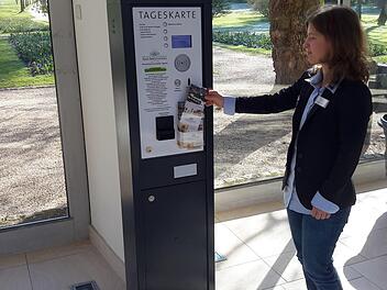 Gästebetreuerin Simone Nickolai bestückt den Tageskarten-Automaten mit Informationsmaterial. Das Gerät in der Wandelhalle des Staatsbades ist momentan Gesprächsthema in Bad Brückenau. Die Meinungen über die Neuerung gehen auseinander. Foto: Rolf Pralle