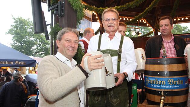 Mit zwei Schl&auml;gen zapfte Wolfgang Beiergr&ouml;&szlig;lein das Fass an. Danach stie&szlig; er mit Landrat Klaus L&ouml;ffler an. Foto: Marian Hamacher