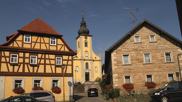 Blick auf die Dorfkirche zwischen Fachwerkh&auml;usern und einem der traditionellen Steinh&auml;user. Foto: G&uuml;nther Geiling