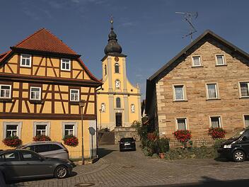 Blick auf die Dorfkirche zwischen Fachwerkhäusern und einem der traditionellen Steinhäuser. Foto: Günther Geiling
