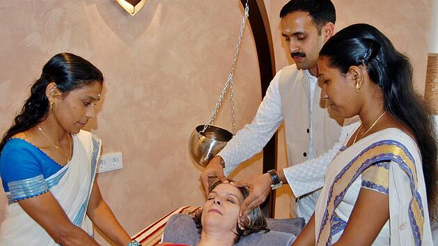 Dr. Jobin Joy Madukkakuzhy (Kerala) mit seinen indischen Therapeutinnen bei der Behandlung einer Patientin. : Archiv Sigismund von Dobsch&uuml;tz