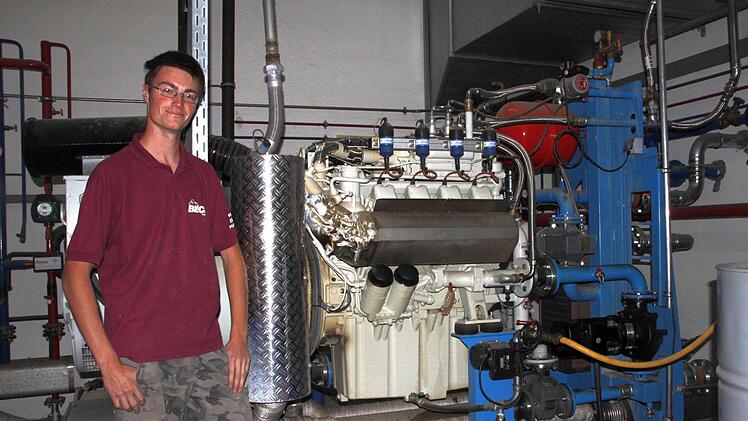 Der 19-jährige Stefan Greif vor einem der beiden Motoren, die mit dem Biogas angetrieben werden.