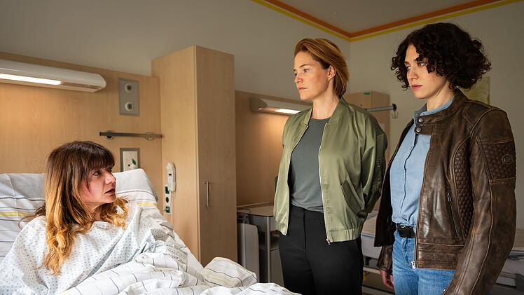 Lu Frey (Patricia Aulitzky, Mitte) und  Irene Russmeyer (Fanny Krausz, rechts) besuchen die Ehefrau des Toten (Julia Rosa Peer) im Krankenhaus.