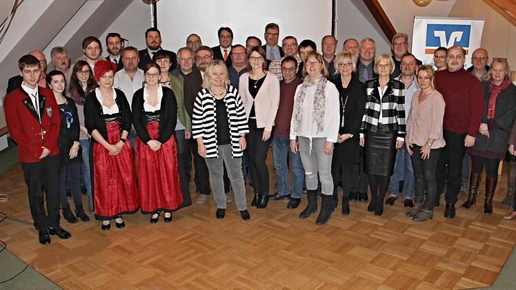 Freudige Gesichter als der Direktor der Raiffeisen-Volksbank Ebern, Christian Senff (hinten Mitte mit roter Krawatte), Spenden an 34 Vereine, Kirchen und Institutionen verteilte.  Fotos: Helmut Will