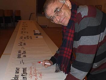 Bernhard Nix trägt einen Kommentar  in die Vater-Unser-Rolle ein.