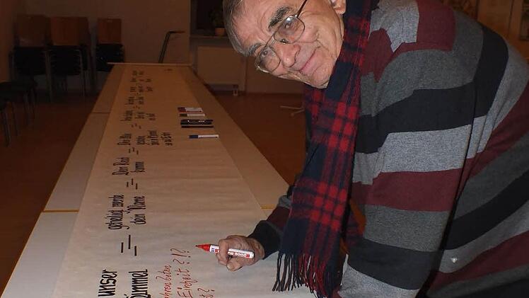 Bernhard Nix trägt einen Kommentar  in die Vater-Unser-Rolle ein.