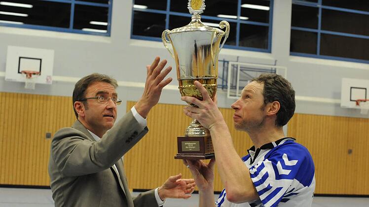 Da ist das Ding: Manfred Klabouch als Vertreter der Bad Kissinger Spielbank überreicht den Pokal an Jörg Holler vom FC 06. Foto: Hopf