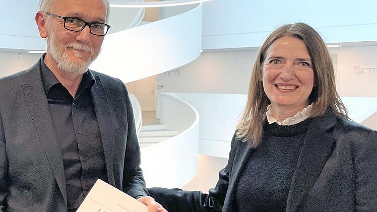 Seit 25 Jahren Hausmeister am Emil-von-Behring-Gymnasium in Spardorf: Schulleiterin Nora Leykam (rechts) gratuliert Thomas Kozlik zum Dienstjubiläum.