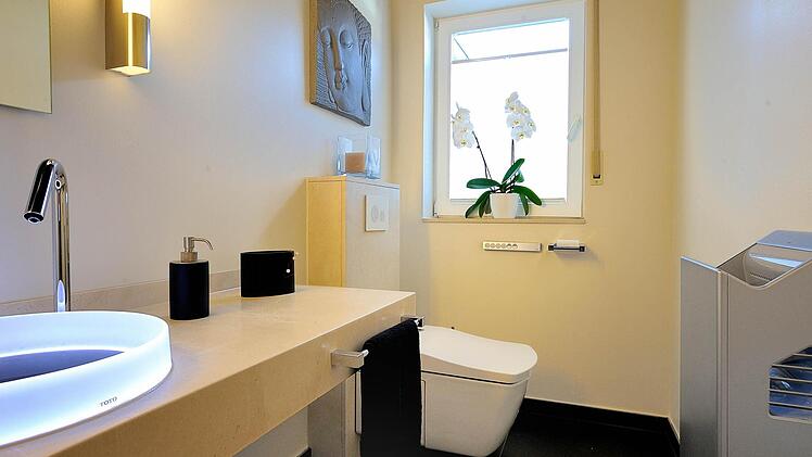 Dieses moderne Bad mit Dusch-WC verfügt über ein Waschbecken mit Sensortechnik und einen automatischen Händetrockner.  Foto: Aqua Cultura/Wolfgang John