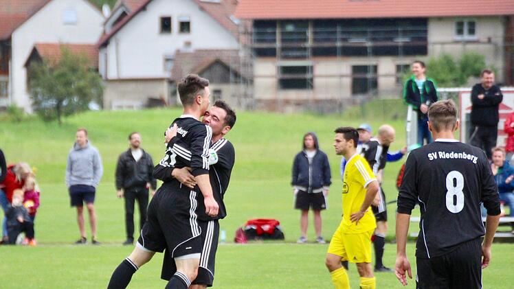 Pure Freude: Riedenbergs Stürmer Kevin Lormehs erzielt das entscheidende Tor und wird von Kapitän Benedikt Carton gedrückt. Thulbas Coach Victor Kleinhenz steht etwas fassungslos daneben. Foto: Sebastian Schmitt
