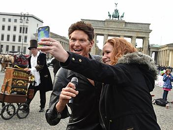 Teresa fotografiert in Berlin vor dem Brandenburger Tor ein Selfie mit der Wachsfigur von US-Sänger David Hasselhoff (Symbolbild).  Foto: Jens Kalaene/dpa