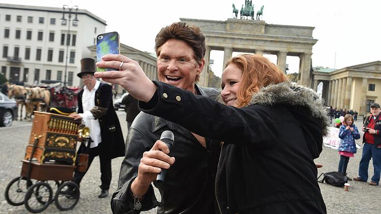 Teresa fotografiert in Berlin vor dem Brandenburger Tor ein Selfie mit der Wachsfigur von US-Sänger David Hasselhoff (Symbolbild).  Foto: Jens Kalaene/dpa