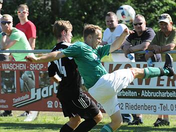 Der Riedenberger Manuel Schuhmann (rechts) schlägt den Ball vor dem Sander Lukas Hager weg.