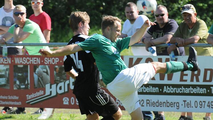 Der Riedenberger Manuel Schuhmann (rechts) schlägt den Ball vor dem Sander Lukas Hager weg.