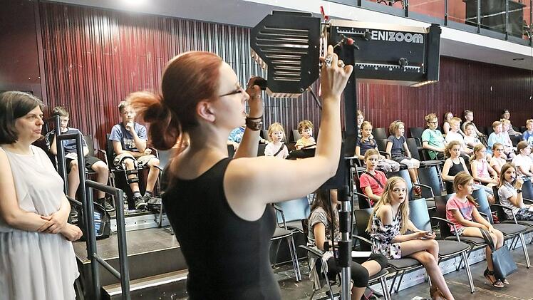Professorin Sabine Vogt (links im antiken Gewand) und Theaterpädagogin Ramona Parino am Scheinwerfer erklärten ca. 100 Kindern, wie Beleuchtung funktioniert.  Fotos: Barbara Herbst