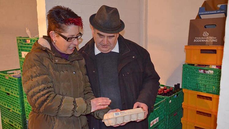 Pfarrer Bernhard Friedmann lässt sich von Debrah Neser die Lagerräume und die Voratshaltung der Burgebracher Tafel zeigen. Foto: Andrea Spörlein