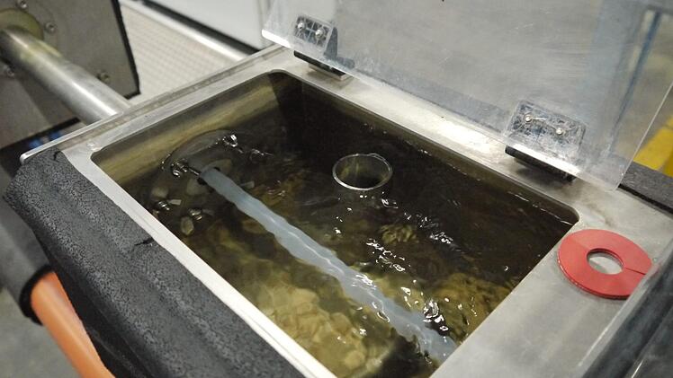 Die heißen Kunststoffrohre werden mit Wasser gekühlt.