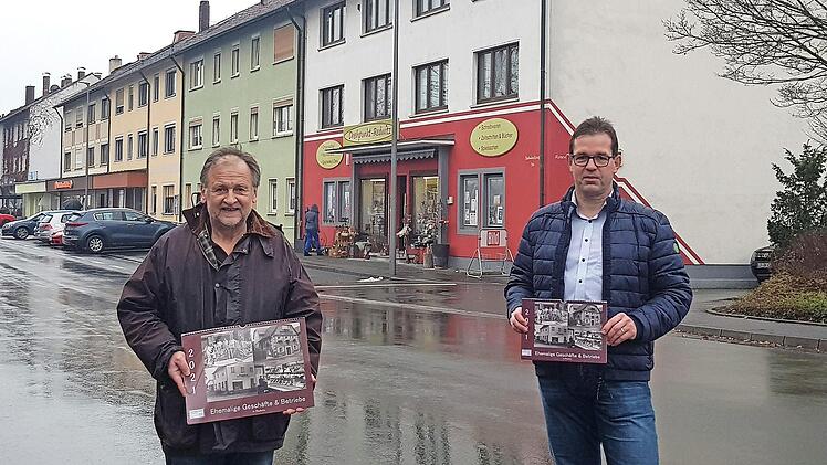 Jochen Körner (links) und Jürgen Gäbelein mit dem Kalender in der Bahnhofstraße, in der sich einige Geschäfte befinden. Foto: Thomas Micheel