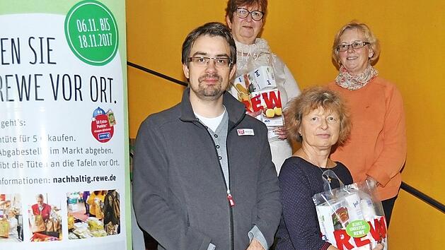 Marktleiter Martin Kolbe &uuml;bergab die fertig gepackten Spendent&uuml;ten an die Vorstandsmitglieder der Tafel Burgkunstadt. 270 Kunden hatten f&uuml;r je f&uuml;nf Euro eine T&uuml;te gekauft. Foto: Ingrid Kohles