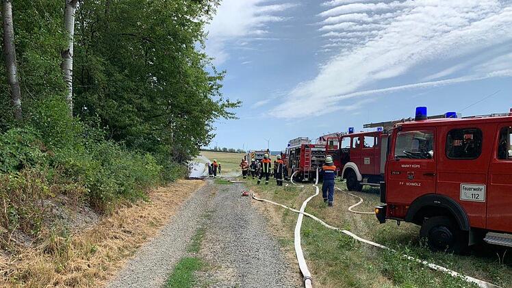 Die Einsatzkräfte haben sich  mit zahlreichen Einsatzfahrzeugen am Waldrand in Au positioniert.FW Kronach