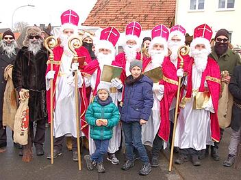 Die Schar der Nikoläuse und Ruprechte mit Organisator Mathias Mangold (links), den Nachwuchs-Nikoläusen Jannis (links) und Noah Bötsch sowie Kutscher Paul Schmitt (rechts). Dahinter Kutschenführer Wolfgang Bötsch, Edgar und Walter Reininger sowie Stefan Back (Traktor).  Foto: Manfred Mellenthin