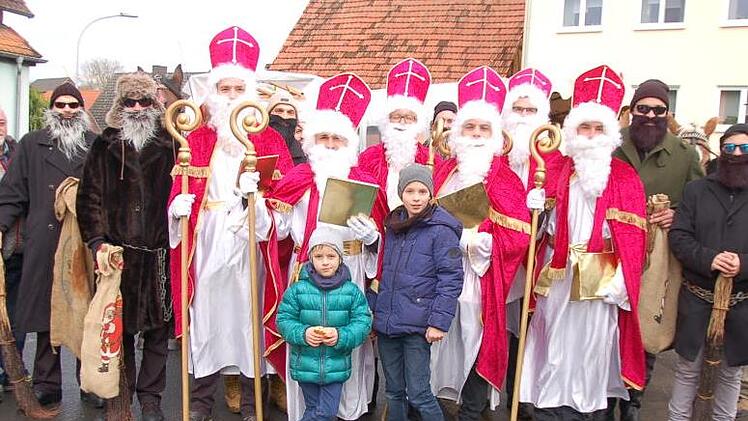 Die Schar der Nikoläuse und Ruprechte mit Organisator Mathias Mangold (links), den Nachwuchs-Nikoläusen Jannis (links) und Noah Bötsch sowie Kutscher Paul Schmitt (rechts). Dahinter Kutschenführer Wolfgang Bötsch, Edgar und Walter Reininger sowie Stefan Back (Traktor).  Foto: Manfred Mellenthin
