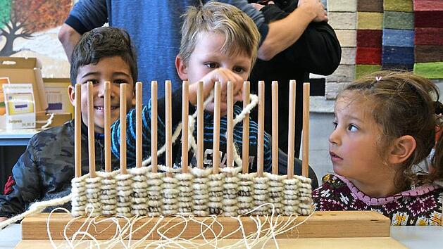 Junge Besucher versuchen sich beim St&auml;bchenweben.  Foto: Anna Krug