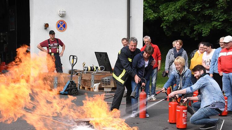 Drei AWO-Mitarbeiter löschen den Brand.