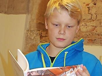 Bei der Buchpräsentation in der ehemaligen Kronacher Synagoge schmökerte der elfjährige Lucas Eilers s in den "Kronacher G´schichten".  Foto: Heike Schülein
