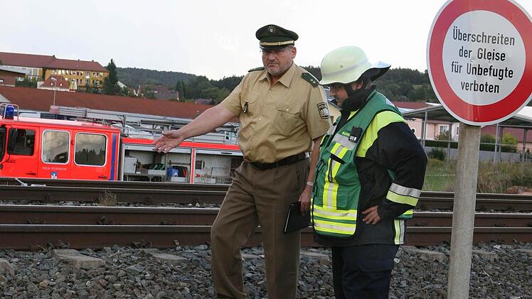 Der Lichtenfelser Polizeichef Willibert Lankes zeigt auf die Stelle, wo immer wieder die Gleise überquert werden, obwohl ein Schild auf die Gefahr hinweist. Foto: Stefan Johannes