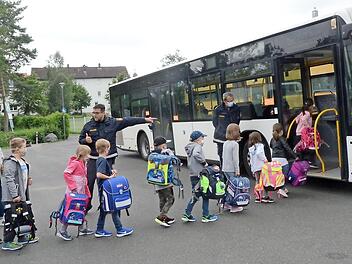 Schon das Einsteigen in den Bus will gelernt sein und bedarf gewisser Verhaltensregeln. Die beiden Polizeibeamten Heiko Sesselmann (links) und Thomas Graf hatten alle Hände voll zu tun, aber ihre Anweisungen wurden gehorsam von den Kindern befolgt.  Foto: Karl-Heinz Hofmann